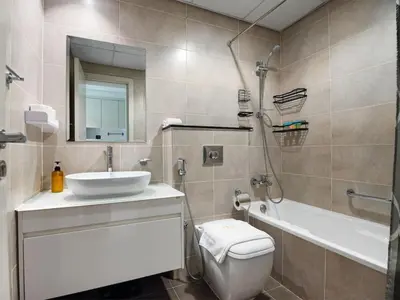 a bathroom with a sink and a toilet and a tub at Cozy and Stylish Studio Retreat in DAMAC Hills in Dubai