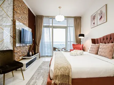 a bedroom with a large bed and a large window at Cozy and Stylish Studio Retreat in DAMAC Hills in Dubai