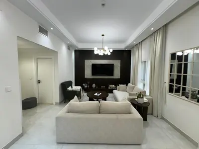 a living room with a couch and a table at Lovely Brand new 3 BR with maids room in Dubai