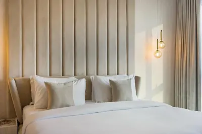 a bed with white sheets and pillows in a room at Durrani Homes - Lumina Grand 3BR with Burj khalifa and Fountain Views in Dubai
