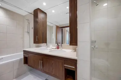 a bathroom with a sink and a tub and a mirror at Durrani Homes - Lumina Grand 3BR with Burj khalifa and Fountain Views in Dubai