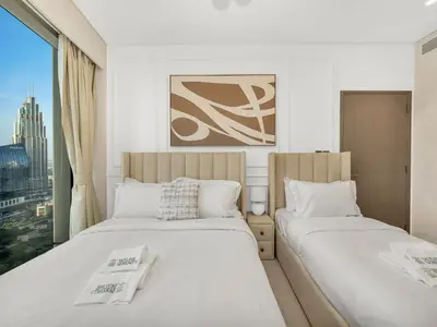 two beds in a room with a window at Grandeur 2 Bedroom Apartments I Burj Khalifa & Fountain Views I Free Parking, Gym, Pool, Wi-Fi & PS5 I by Skyline Serenity in Dubai