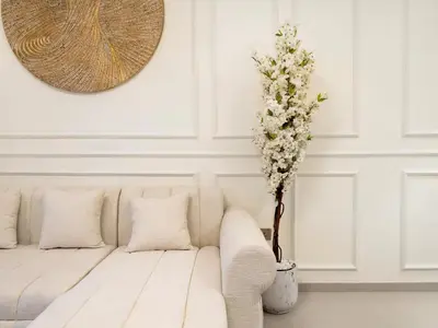 a white living room with a couch and a vase with flowers at Grandeur 2 Bedroom Apartments I Burj Khalifa & Fountain Views I Free Parking, Gym, Pool, Wi-Fi & PS5 I by Skyline Serenity in Dubai