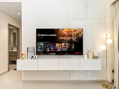 a living room with a tv on a white wall at Grandeur 2 Bedroom Apartments I Burj Khalifa & Fountain Views I Free Parking, Gym, Pool, Wi-Fi & PS5 I by Skyline Serenity in Dubai