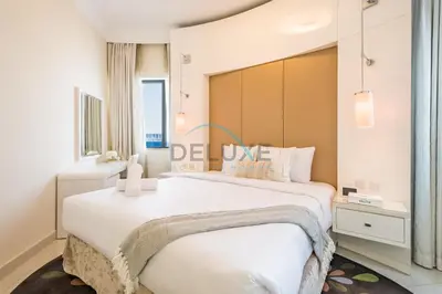 a bedroom with a large white bed and a window at Lovely 2BR at The Signature, Downtown Dubai by Deluxe Holiday Homes in Dubai
