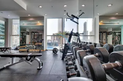a gym with rows of exercise equipment in a building at Stunning 1BR Apartment at Botanica Tower 1, Dubai Marina by Deluxe Holiday Homes in Dubai