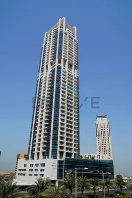 a tall white building with palm trees in front of it at Stunning 1BR Apartment at Botanica Tower 1, Dubai Marina by Deluxe Holiday Homes in Dubai