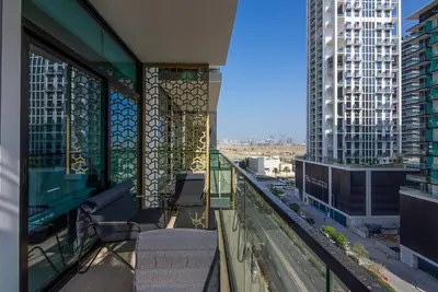 a balcony with chairs and a view of a city at Binghatti Emerald, JVC- Charming 1-BR Apartment in Dubai