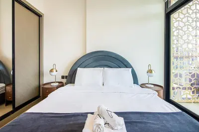 a bedroom with a large bed with shoes on it at Binghatti Emerald, JVC- Charming 1-BR Apartment in Dubai