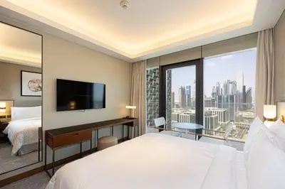 a hotel room with a large bed and a large window at Stunning Address Opera 3Bedroom in Dubai