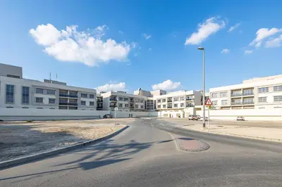 an empty street in front of a large building at 2BR API 1000 Community View Jumeirah in Dubai