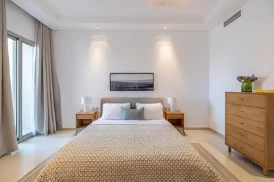 a bedroom with a large bed and a dresser at 2BR API 1000 Community View Jumeirah in Dubai