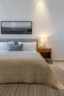 a bedroom with a bed and a table with a lamp at 2BR API 1000 Community View Jumeirah in Dubai