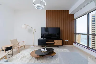 a living room with a flat screen tv and a table at Breathtaking Scenery- JBR Walk- Beach Access in Dubai