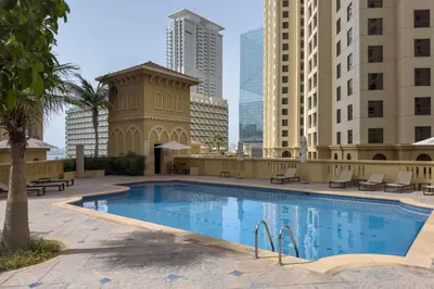 a large swimming pool in a city with tall buildings at Breathtaking Scenery- JBR Walk- Beach Access in Dubai