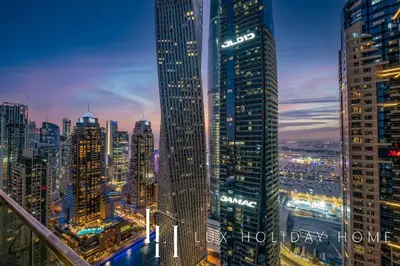 a view of a city skyline at night at LUX The Marina Gate Sea View Suite in Dubai