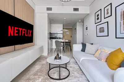 a living room with a white couch and a table at New Cozy 1BR in the Heart of the City in Dubai
