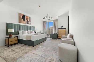 a bedroom with a bed and a couch and a chair at Large 1 BR Duplex With Lake View in Dubai