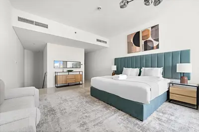 a bedroom with a large bed and a couch at Large 1 BR Duplex With Lake View in Dubai