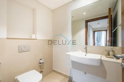 a white bathroom with a sink and a mirror at Spacious 3BR Apartment with Assistant Room & Stunning Creek Views in The Dubai Creek Residences South Tower 1, Creek Harbour by Deluxe Holiday Homes in Dubai