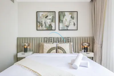 a bedroom with a white bed with three pictures on the wall at Spacious 3BR Apartment with Assistant Room & Stunning Creek Views in The Dubai Creek Residences South Tower 1, Creek Harbour by Deluxe Holiday Homes in Dubai