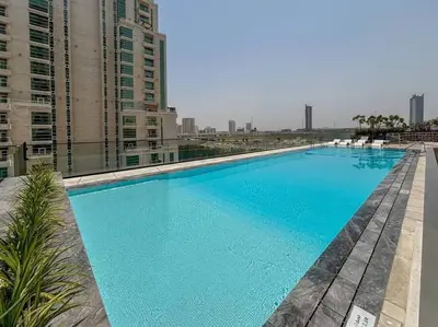 a large blue swimming pool on top of a building at HiGuests - Luxury Apt in the Heart of JVC at Binghatti Nova in Dubai