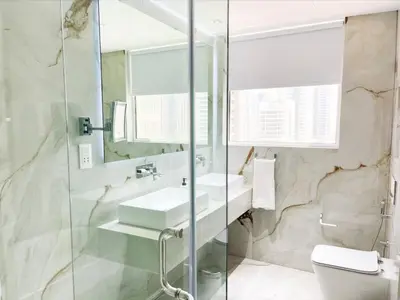 a bathroom with a sink and a mirror and a toilet at Luxury 4 Bed Apartment in Sadaf 8 on The Walk JBR in Dubai