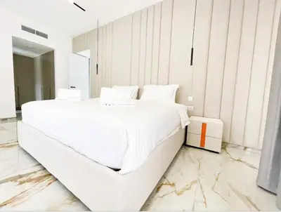 a white bedroom with a large bed with marble floors at Luxury 4 Bed Apartment in Sadaf 8 on The Walk JBR in Dubai