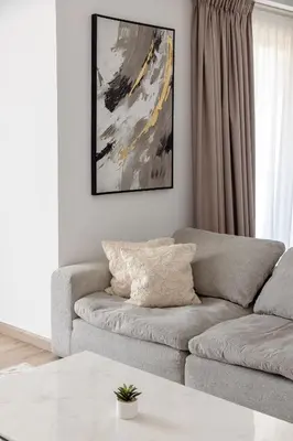 a living room with a couch and a painting on the wall at Beautiful and bright 1 bedroom apartment! Sofia ! in Dubai
