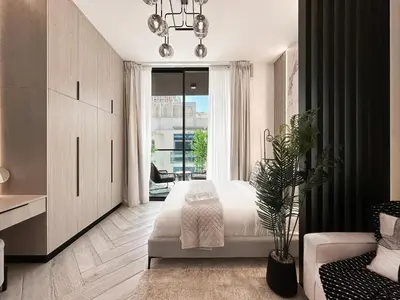 a bedroom with a bed and a couch and a window at Indulge in a Regal Retreat at JVC in Dubai