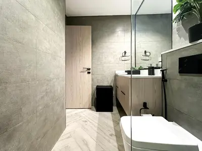 a bathroom with a toilet and a sink and a mirror at Indulge in a Regal Retreat at JVC in Dubai