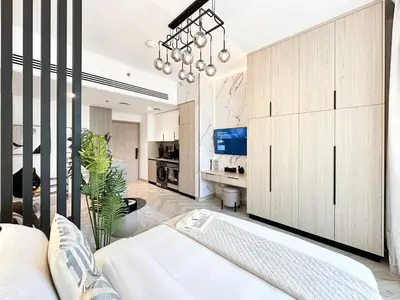 a living room with a white couch and a chandelier at Indulge in a Regal Retreat at JVC in Dubai