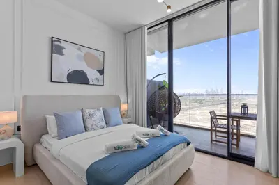 a bedroom with a bed and a large glass window at Elegant Living in 1 BDR at JVC with Top Amenities in Dubai