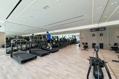 a gym with a row of treadmills and people on treadleys at Elegant Living in 1 BDR at JVC with Top Amenities in Dubai