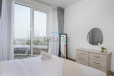 a bedroom with a white bed and a large window at Contemporary 1BR in Al Kifaf Residences West, Bur Dubai by Deluxe Holiday Homes in Dubai