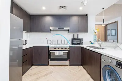 a kitchen with wooden cabinets and a stove top oven at Contemporary 1BR in Al Kifaf Residences West, Bur Dubai by Deluxe Holiday Homes in Dubai