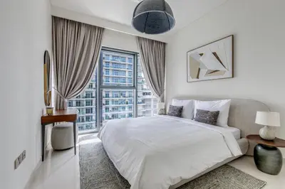 a bedroom with a white bed and a large window at Beach Vista - Private Beach & Palm Jumeirah Views in Dubai
