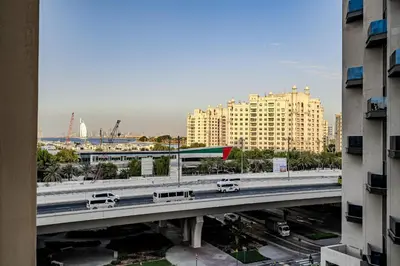a bridge over a highway in a city with buildings at Stylish 2 bedroom apartment with Maid Room I Fairmont South Residence I Palm Jumeirah in Dubai