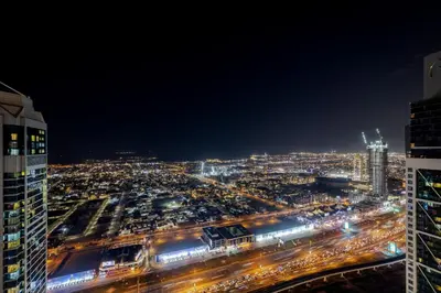 a city at night with a lot of traffic at 64th floor Skyline Pool with Burj Khalifa View in Paramount Hotel Midtown in Dubai