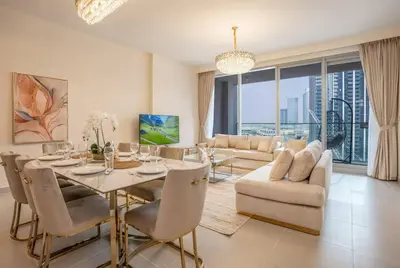 a dining room with a table and chairs and a couch at NewArabian Forte Downtown in Dubai