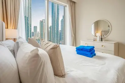 a bedroom with a white bed with a view of a city at NewArabian Forte Downtown in Dubai