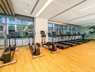 a gym with a row of treadmills and ellipticals at LUXE | Elegant 2BR | Harbour View | Stylish & Cozy in Dubai