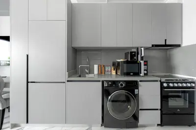 a kitchen with a washing machine and a washer at Modern Meydan Studio Apartment - 15 min Drive to Downtown Dubai Mall in Dubai