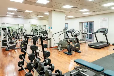 a gym with lots of treadmills and machines at Prime Retreats - steps to Grosvenor Hotel Marina in Dubai
