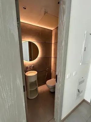 a bathroom with a toilet and a sink and a mirror at Premium 1BHK Apt In Signature living, JVC! Pool view in Dubai