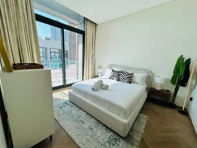a bedroom with a bed with a teddy bear on it at Premium 1BHK Apt In Signature living, JVC! Pool view in Dubai