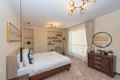 a bedroom with a large bed and a mirror at Rimal 4, JBR- Elegant 2 BR in Dubai