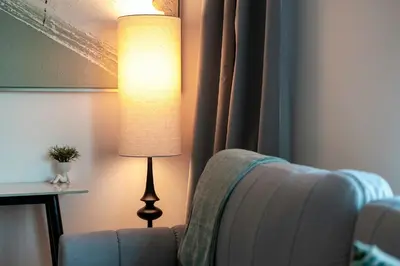 a lamp sitting next to a chair in a room at Moderne 1BR with a lovely marina view in Dubai