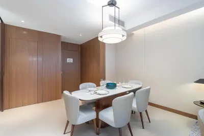 a dining room with a table and white chairs at Spacious 3 Bedroom Apartment in Downtown with Burj Khalifa view in Dubai