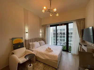 a bedroom with a bed and a tv and a chair at Studio in Azizi Riviera 47 in Dubai